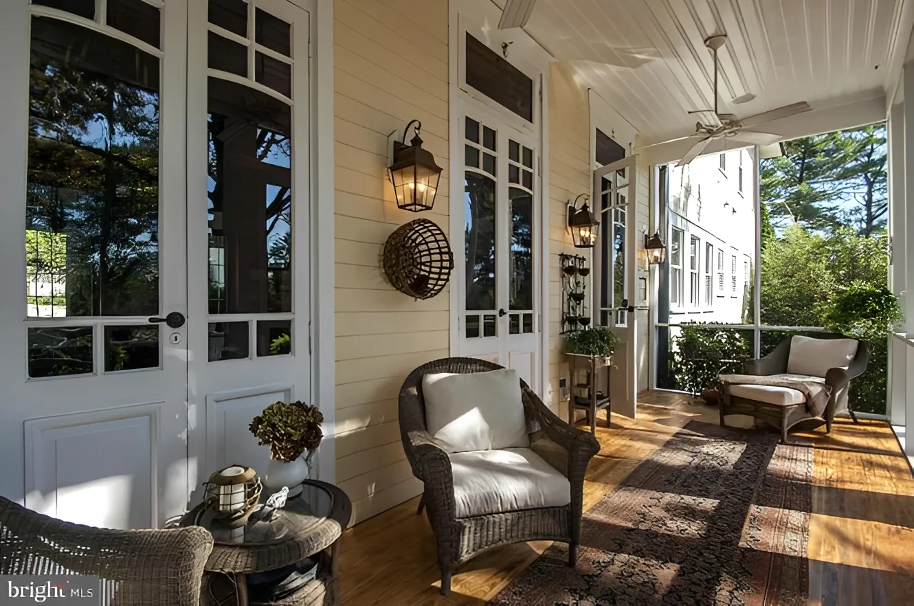 Cozy sunlit porch with wicker furniture.