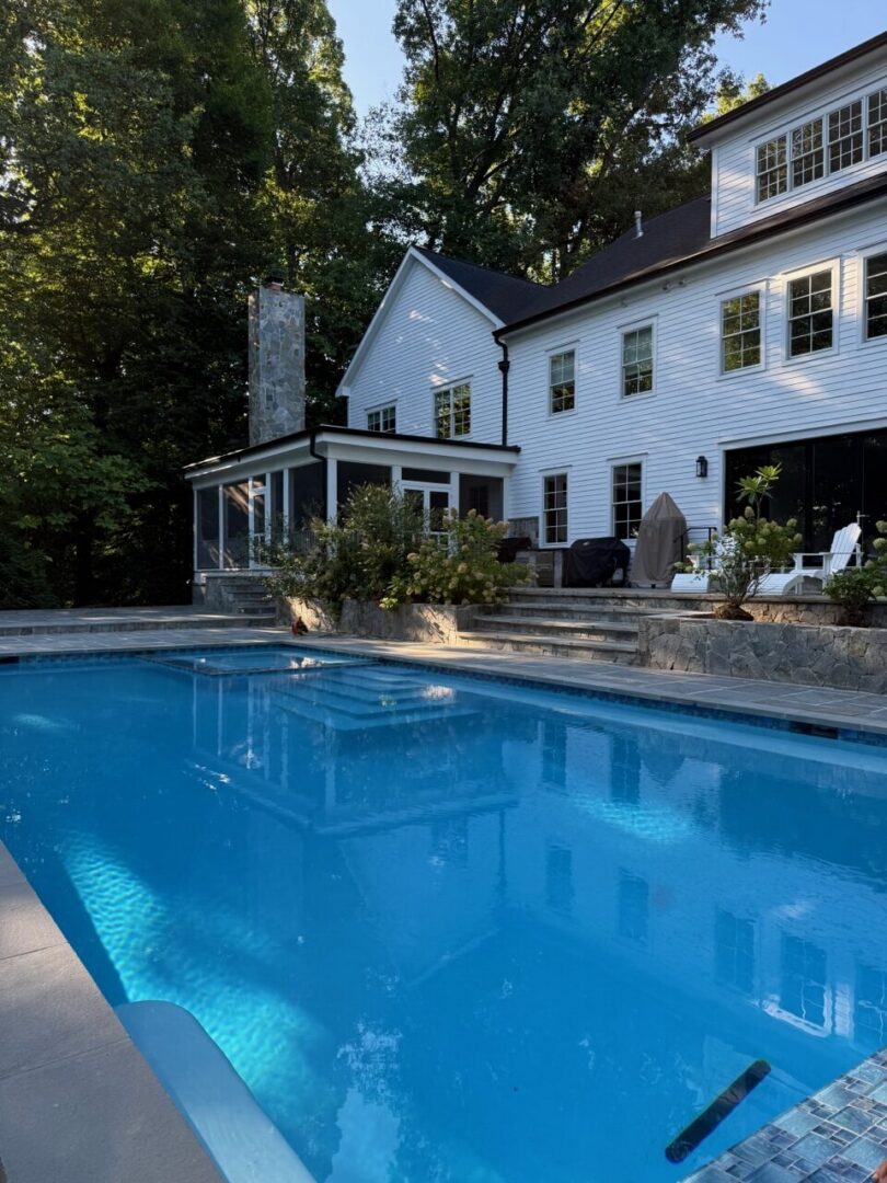House with pool and surrounding trees.