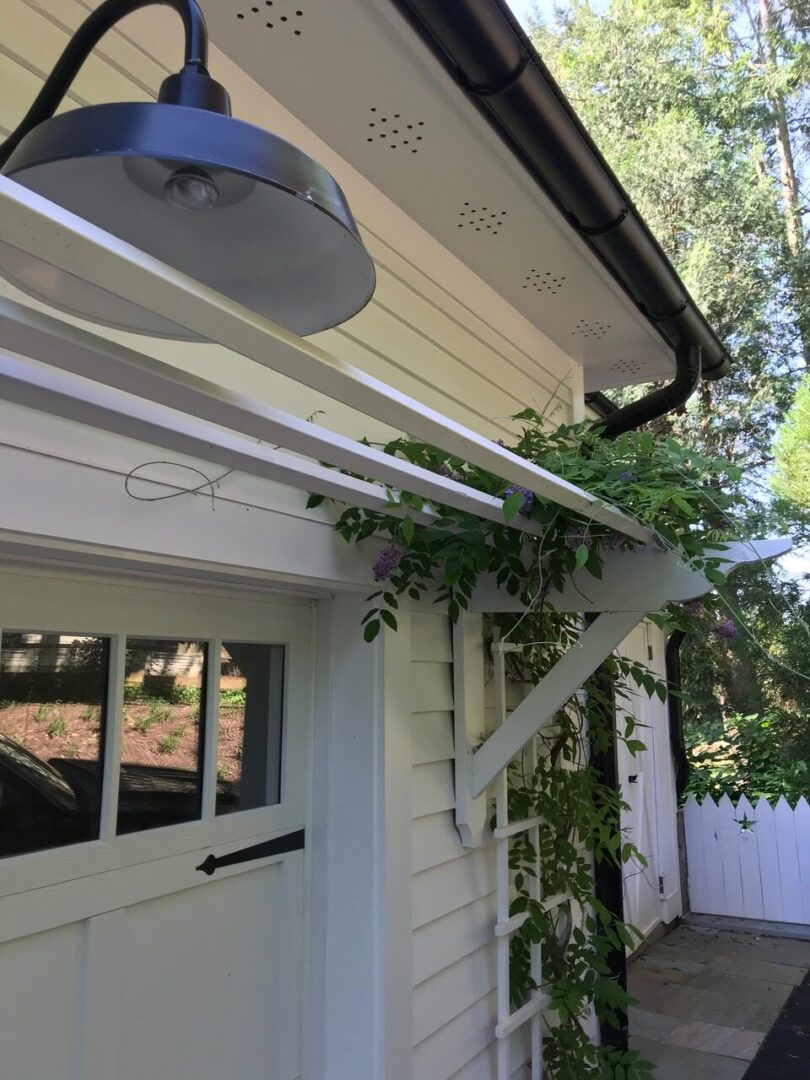 White house exterior with outdoor light fixture.