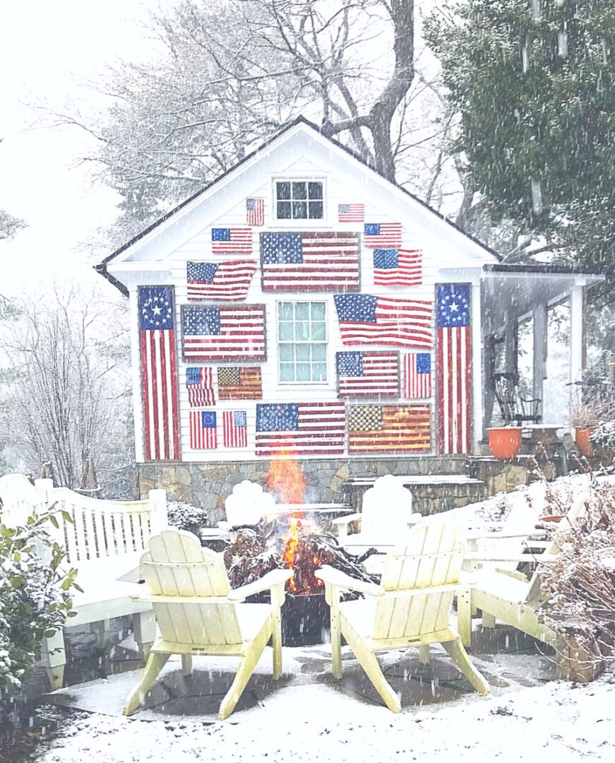 Snowy house with American flags and fire.