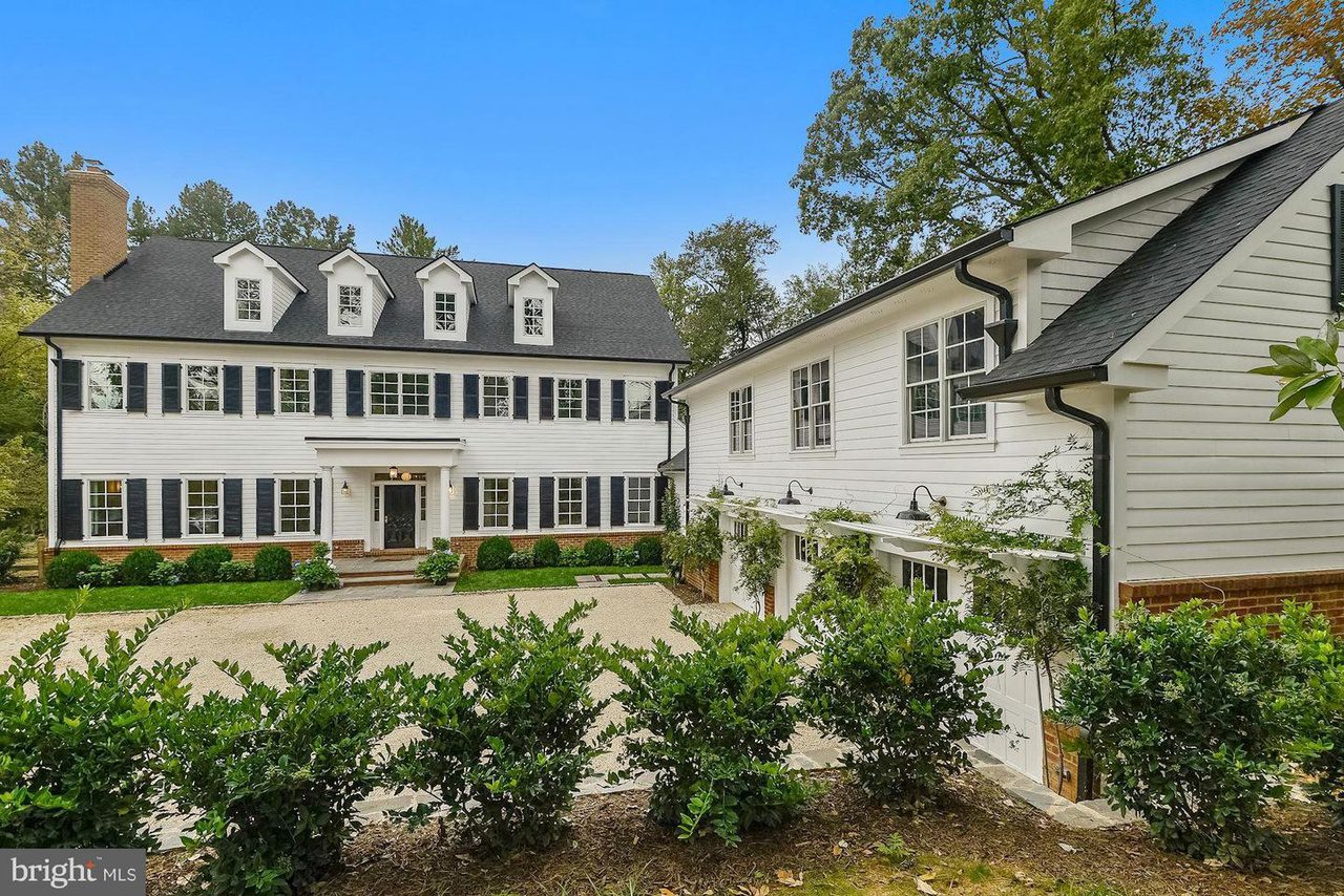 Large white colonial-style house with driveway.