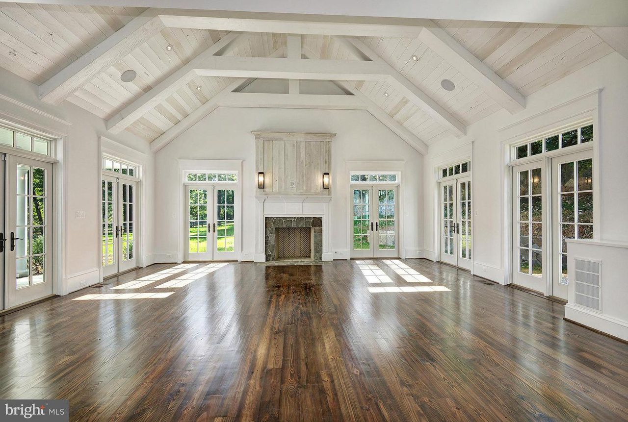 Spacious room with wooden floors and fireplace.