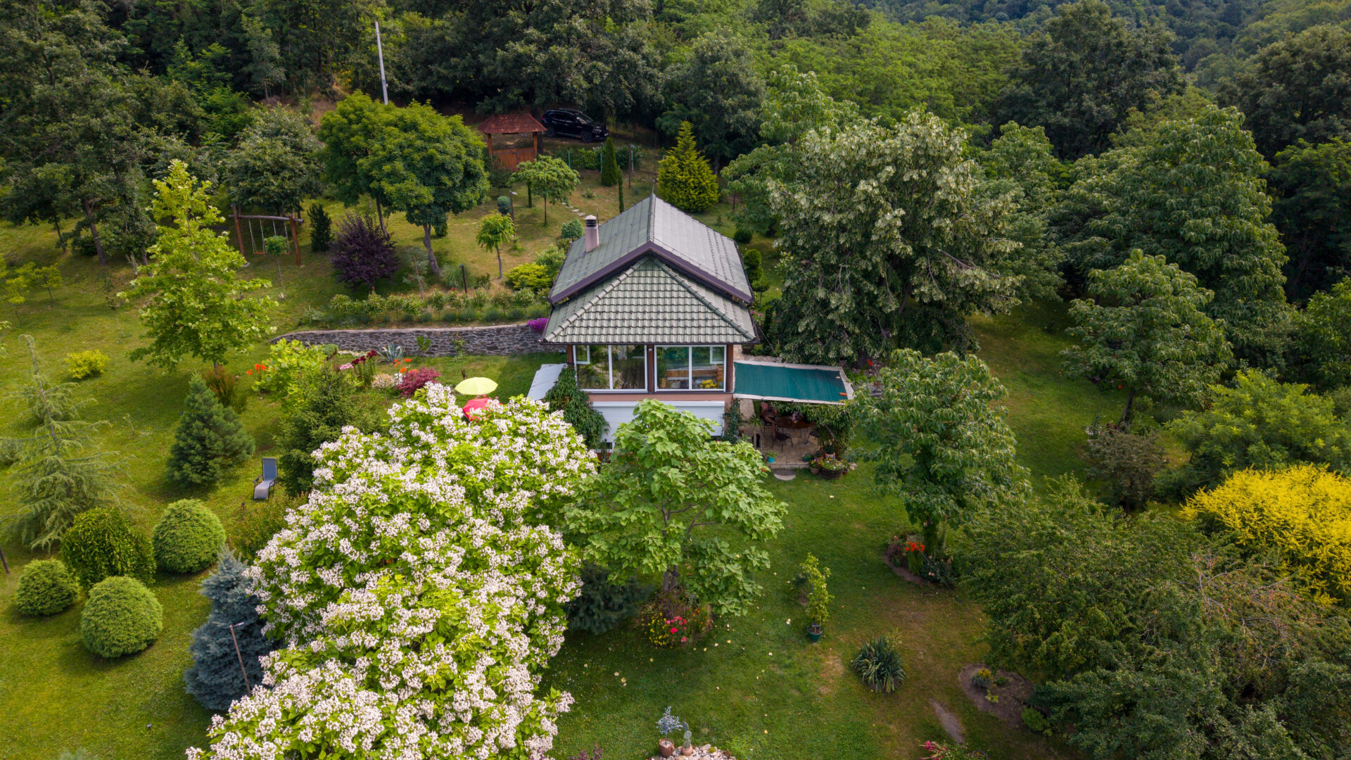 Beautiful house in the countryside, with garden in a backyard, surrounded with forest. Blooming trees, pond, glasshouse are the part of this garden